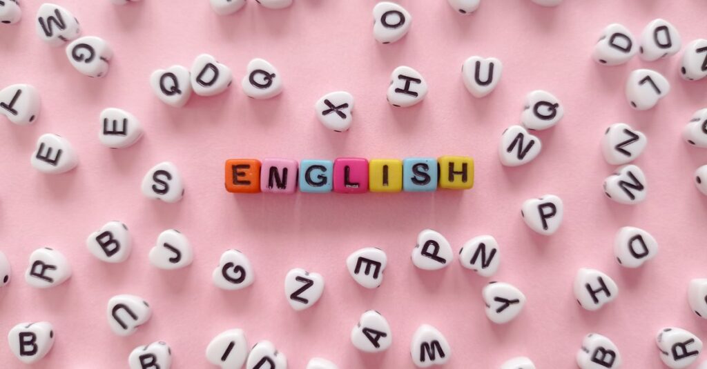 Scattered letter beads form the word 'English' on a pink background, symbolizing language learning.